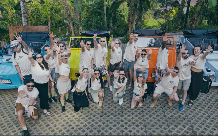 Members in white MetaKizz T-shirts with vintage cars in Bali